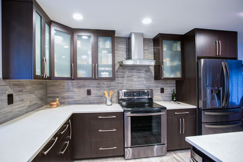 Kitchen with white glassos countertop, cabinets, range hood, oven, and ceiling lights