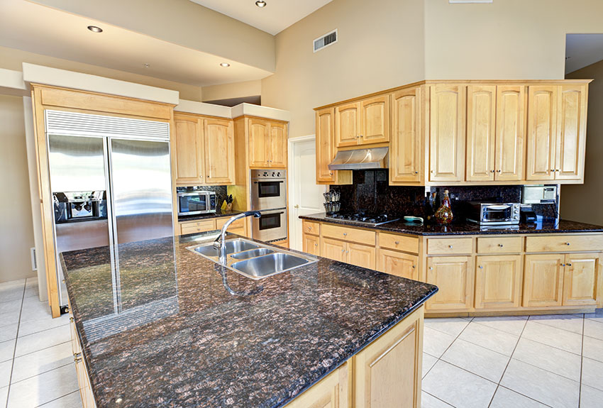 Kitchen with wood cabinets dark granite countertops