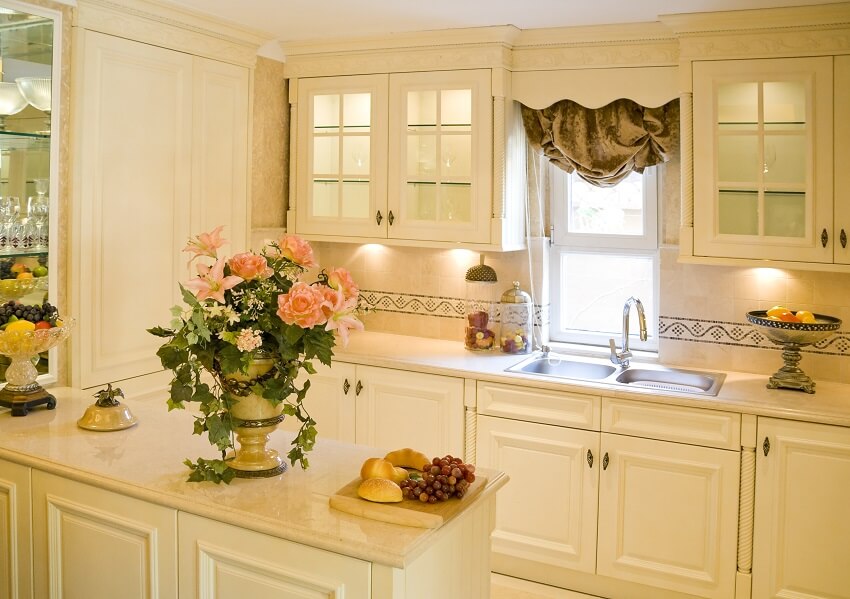 Large kitchen with under cabinet lighting, decors on marble countertop, and a valance curtain
