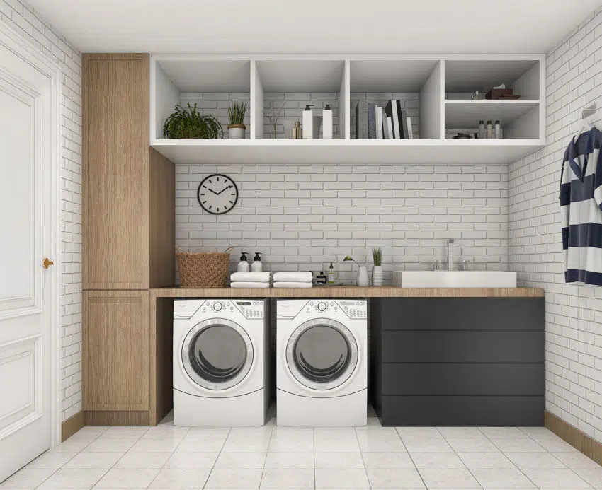 Laundry room with butcher block countertop, chute, washing machines, and shelves