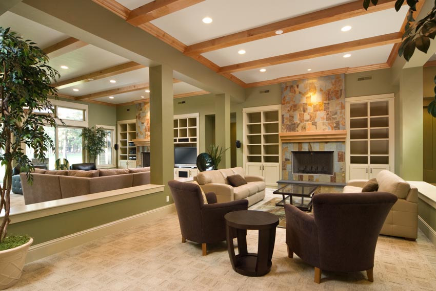 Living room area with couch, chairs, recessed lights, and fireplace