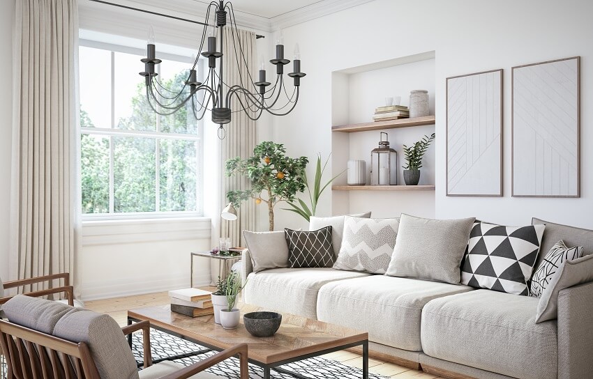 Living room with coffee table, open shelves, chandelier, and sofa with throw pillows