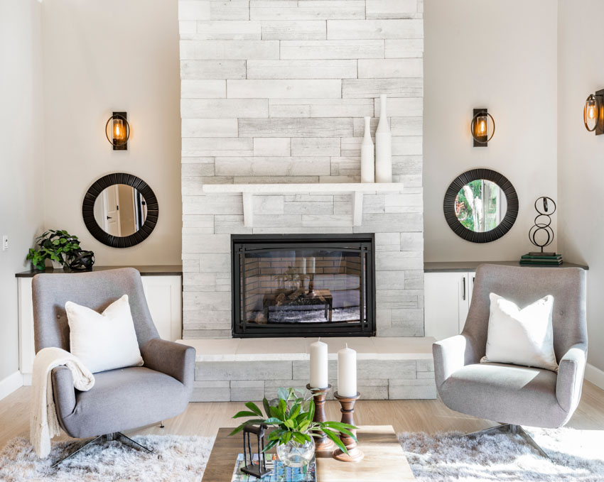 Living room with tile fireplace, chairs, and mirrors