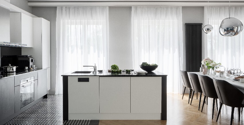 Luxury kitchen with big windows behind white sheer curtains
