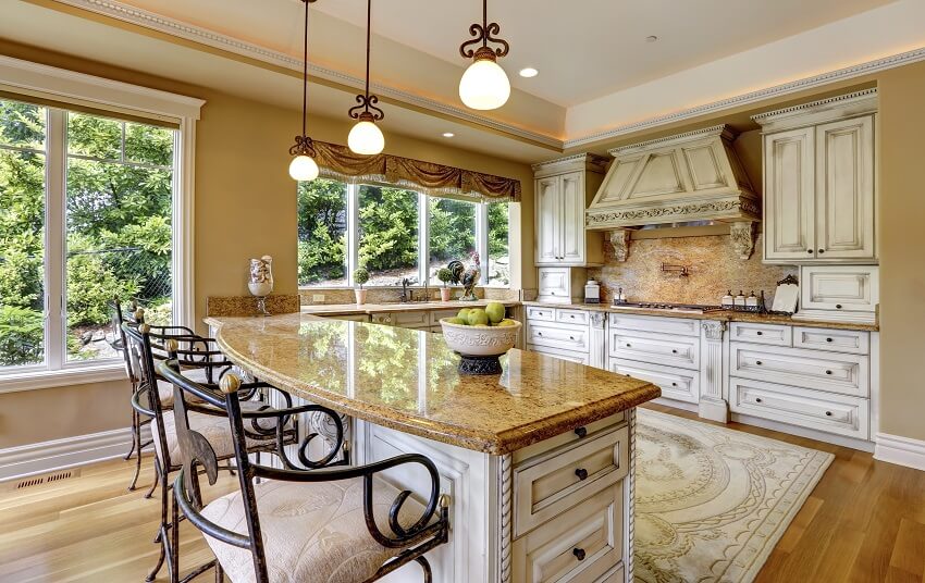 Luxury kitchen with pendant lights, valance curtains, and island with granite countertop and chairs