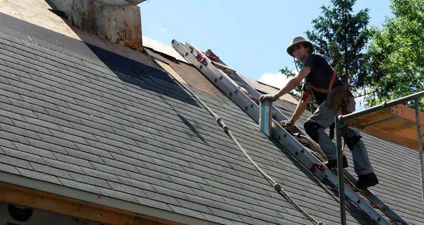 Man climbing up to roof using a ladder