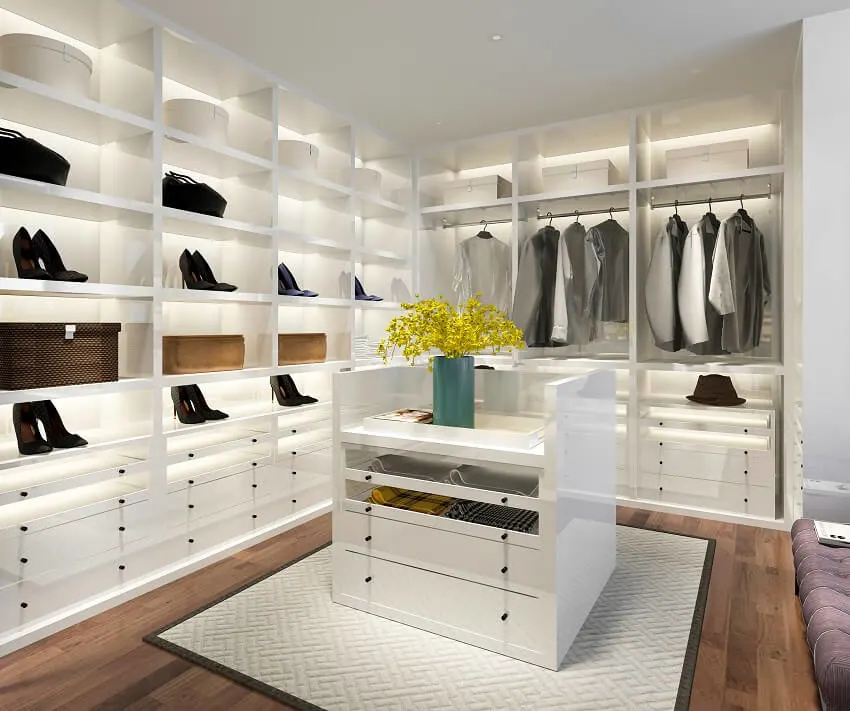 Minimal white wood walk-in closet with wardrobe, wood floor, and decor on top of closet island