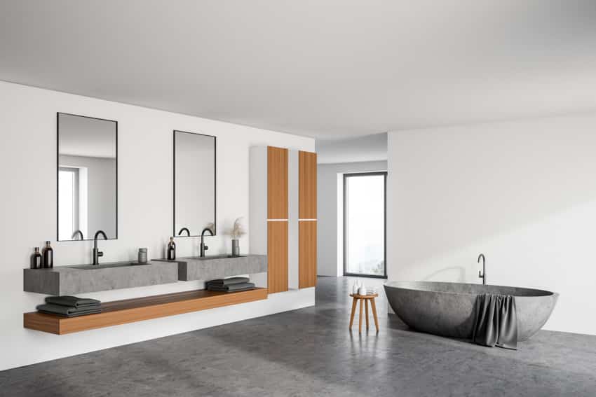 Bathroom with tub, two mirrors and floating shelves