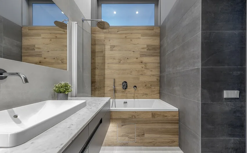 Minimalist tub and shower combo bathroom interior with dark stone tiles and wood wall texture