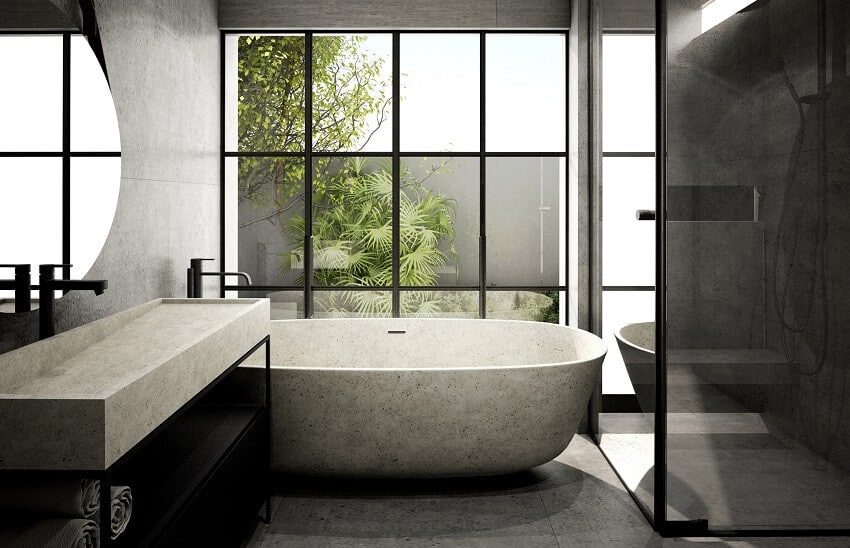 Modern bathroom interior with a stone bathtub, concrete wall and floor, and a large window