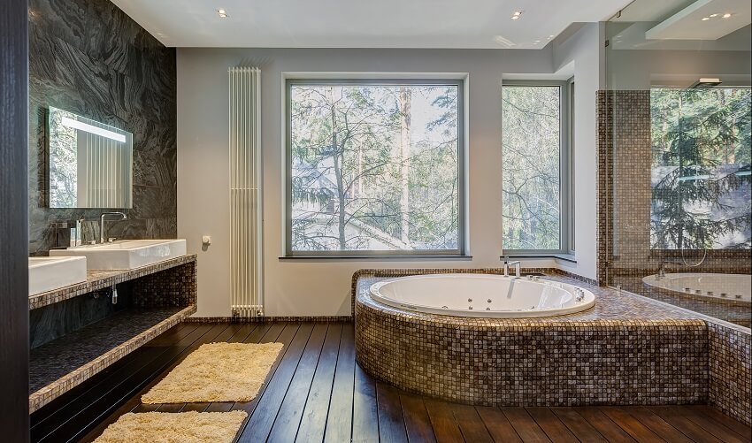 Modern bathroom with vanity, wood floor, and drop-in tub with mosaic tile design