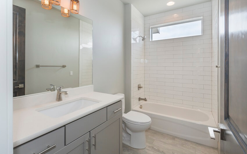 Modern farmhouse bathroom with standard built-in tub, subway tile, and vanity