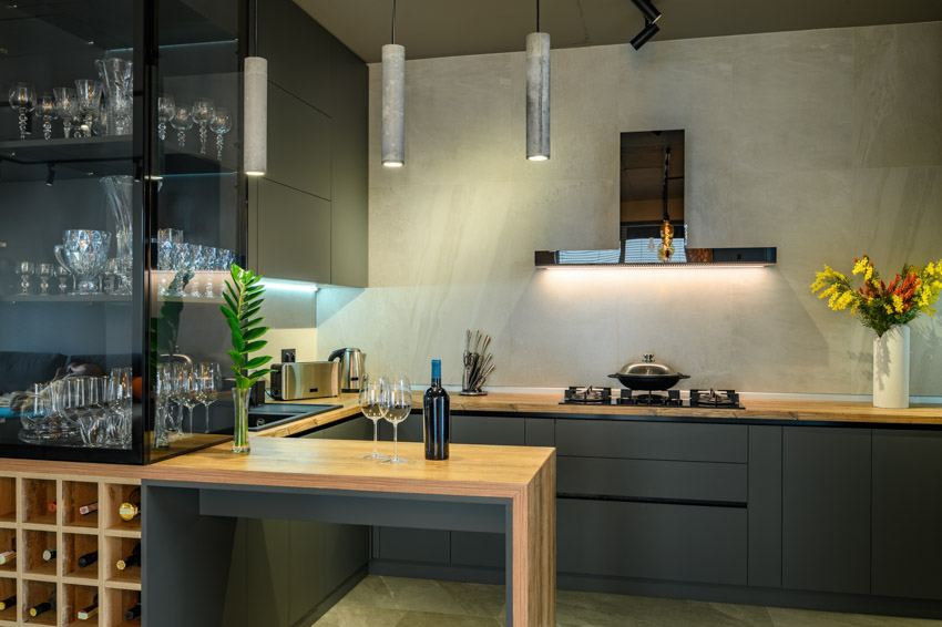 Modern kitchen with wet bar backsplash, countertop, accent lighting, pendant lights and wine storage