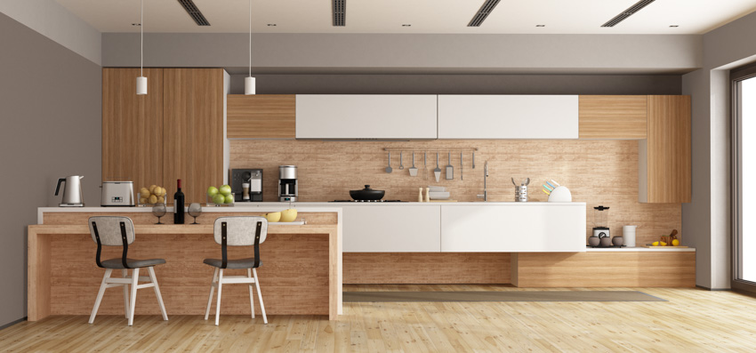 Modern kitchen with wood accent wall, backsplash, wooden flooring, hanging lights, and windows