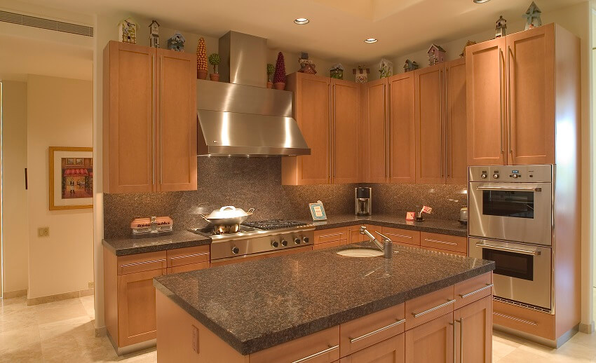 Modern kitchen with wood cabinets, stainless steel appliances, and granite backsplash and countertops