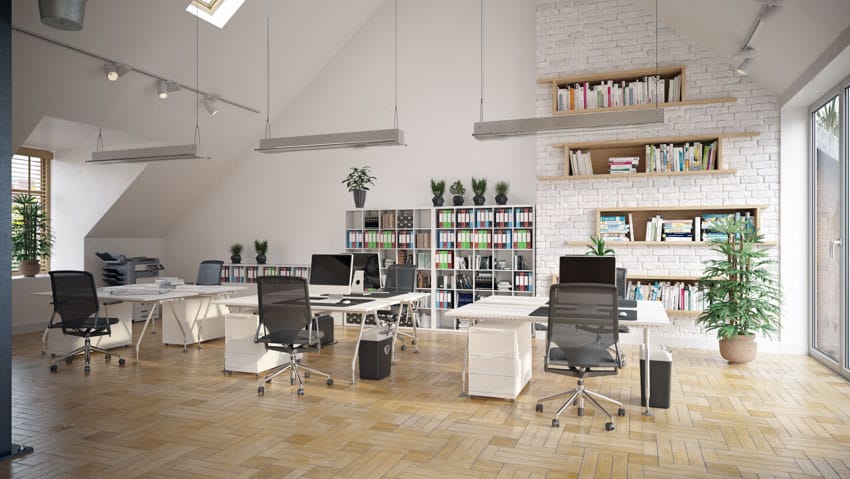 Office space with desks, wood floor, chairs, hanging lights, and windows