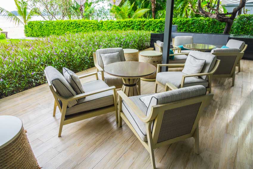Outdoor area with cushioned chairs, wood flooring, and tables