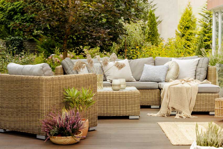 Outdoor deck with wicker furniture, cushions, and pillows