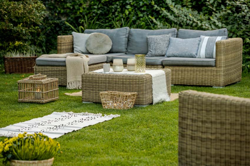 Outdoor garden lawn with wicker furniture, cushions, and pillows