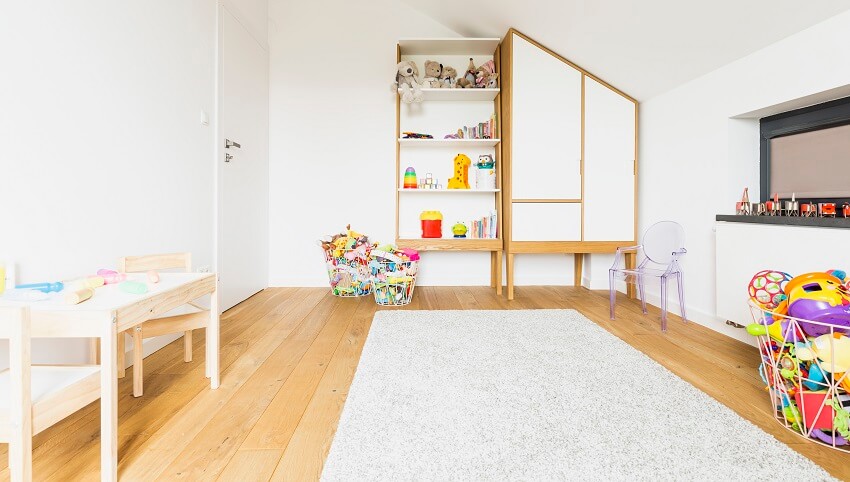 Playroom with hardwood floors, white walls, carpet and toys in baskets
