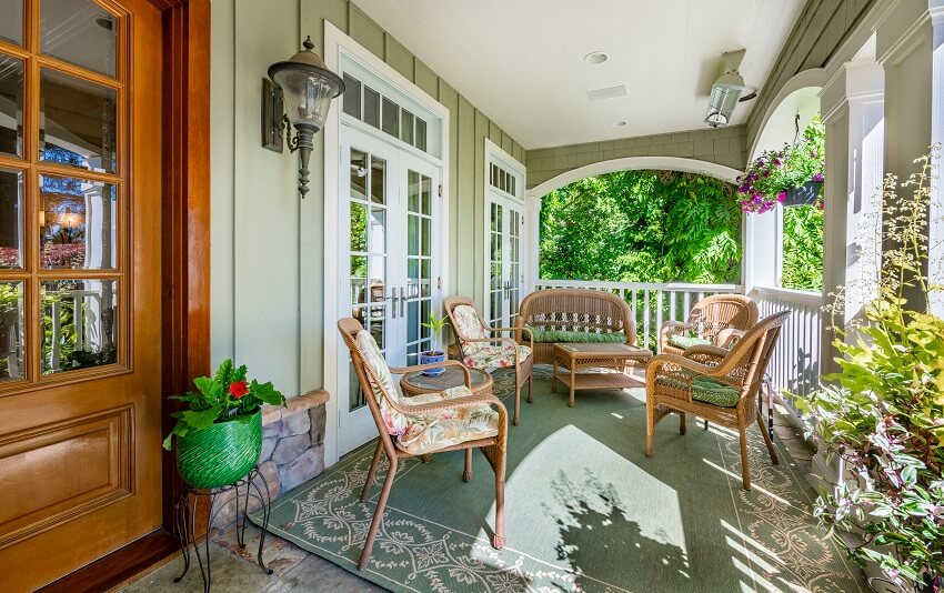 Porch with chairs, coffee table, carpet, lighting fixture, and flowers