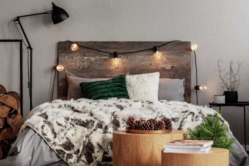 Small guest bedroom with floor lamp, headboard, light bulb decor, and nightstand