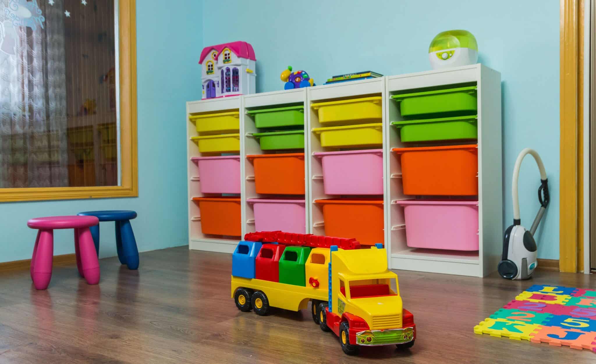 Small playroom with toys on wood floor sky blue walls and toy storage