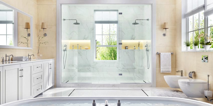 Spacious bathroom with stone resin shower wall, glass door, countertops, toilet, mirrors, and windows