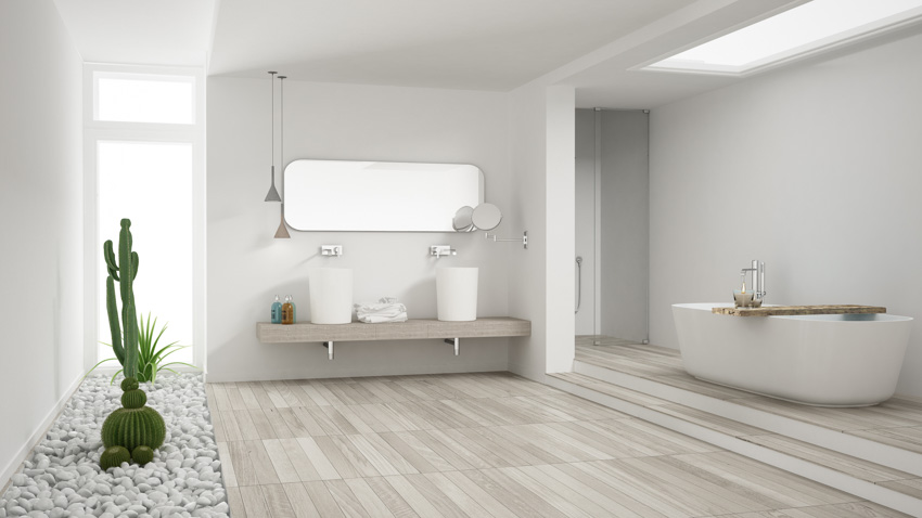 Spacious bathroom with tub, laminate floors, window, and mirror