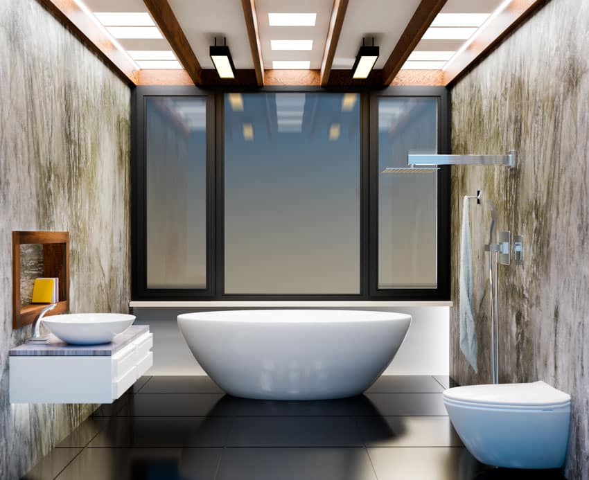 Spacious bathroom with windows, epoxy walls, tub, and toilet