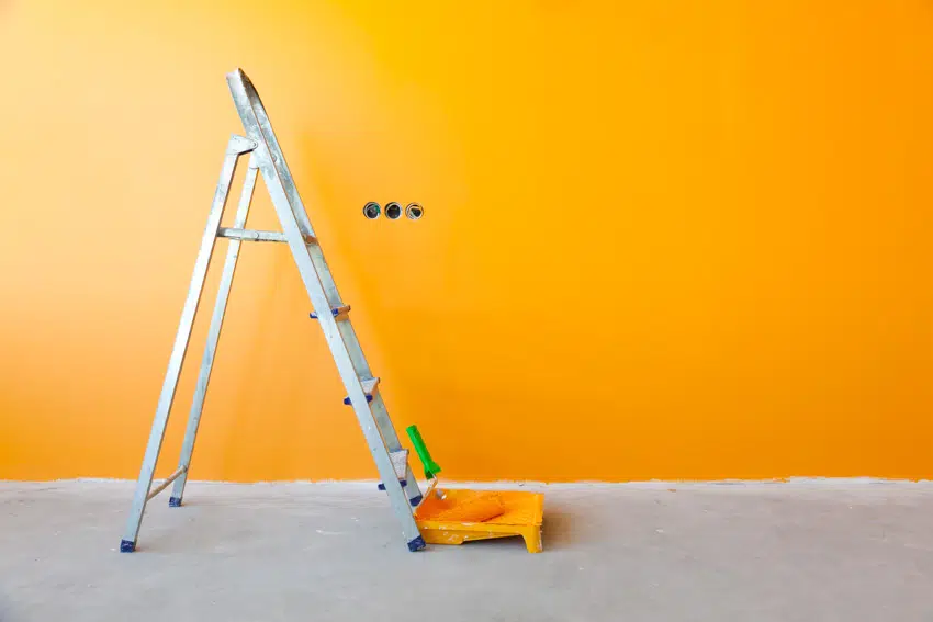 Step ladder near a blank orange wall