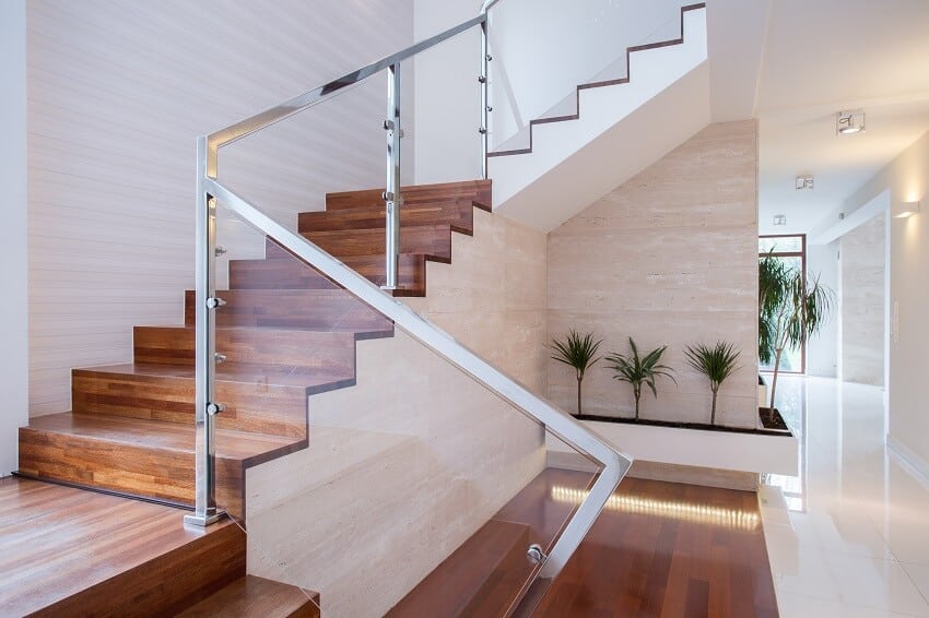 Staircase in bright interior with woodlike flooring and glass and metal railings