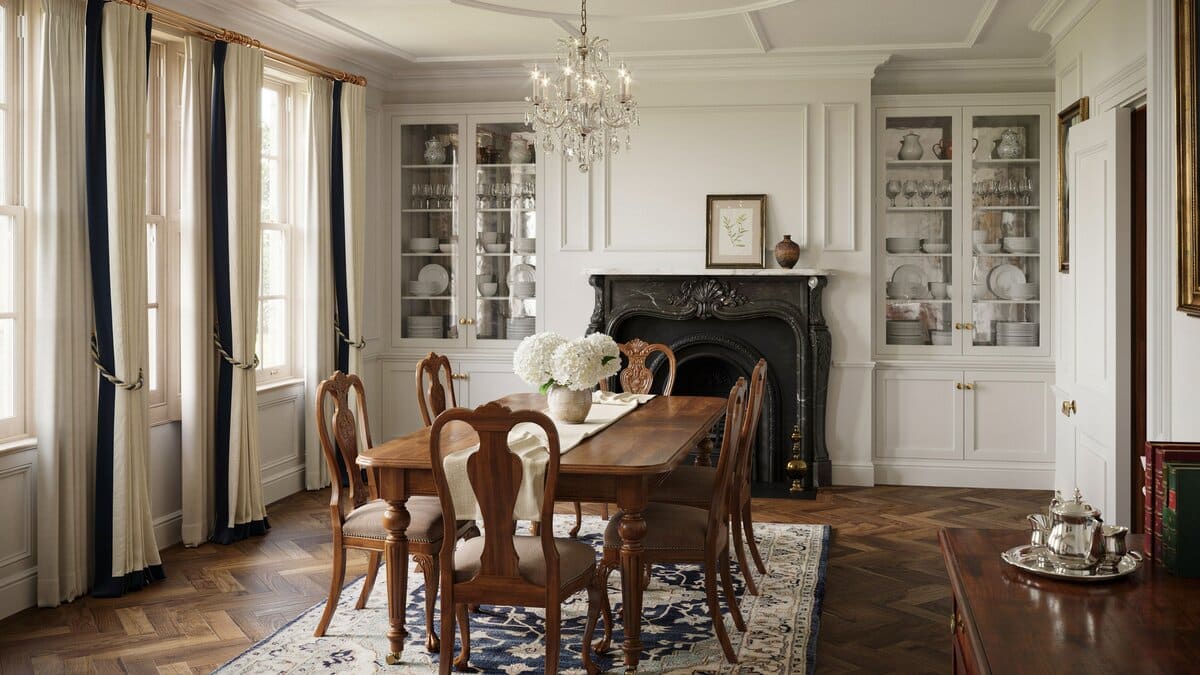 Wood table and chairs on patterned rug near a black fireplace and cabinetry
