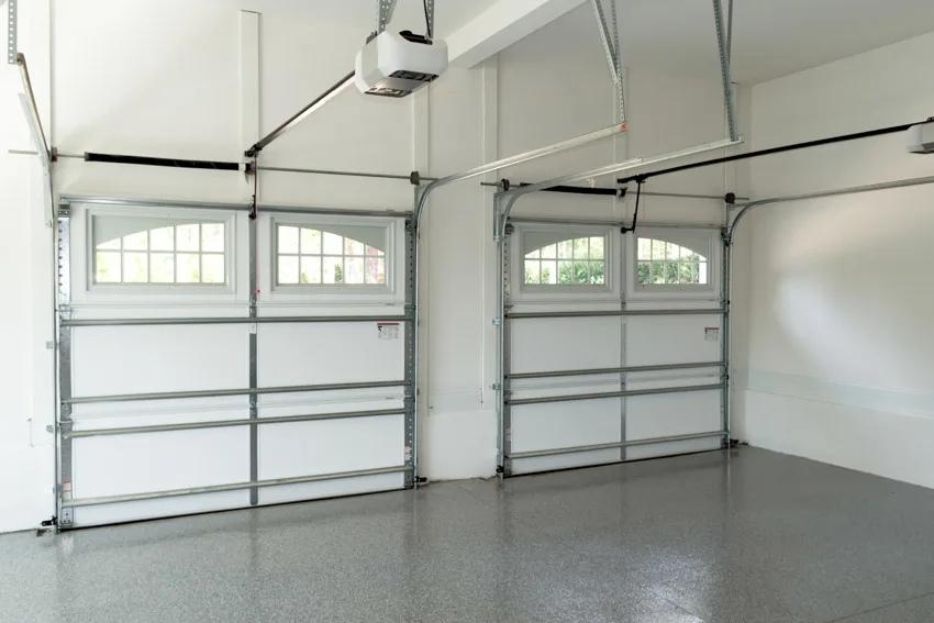 Two car garage with epoxy flooring, and door openers