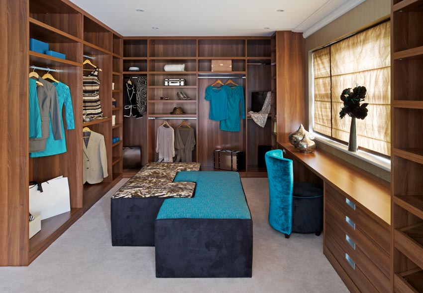 Walk-in closet with seating, drawers, shelves, and window