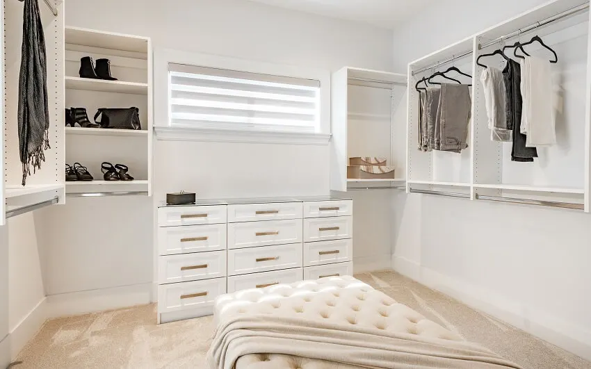Walk-in closet with shelves jewelry drawers and upholstered bench