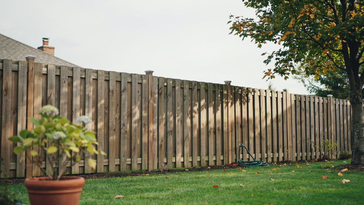 Pressure treated cedar fence with vertical boards around a residential yard