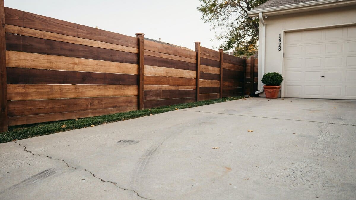 Stained horizontal wood fence beside a residential garage