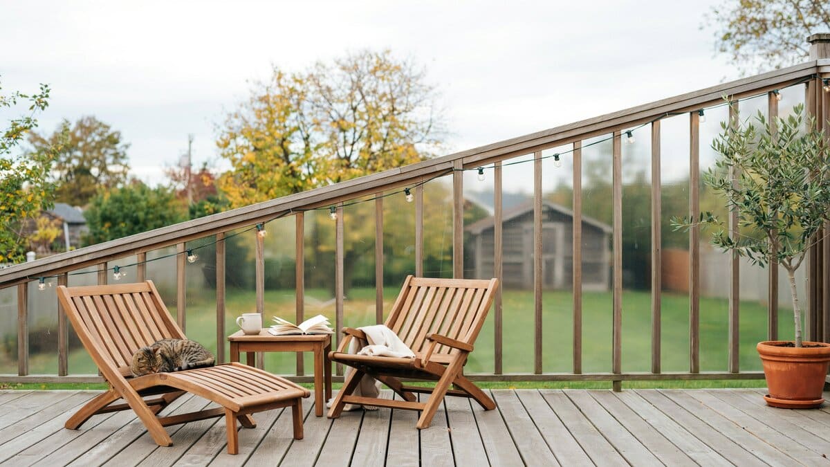 Backyard deck enclosed by a wood frame and frosted glass panel fence