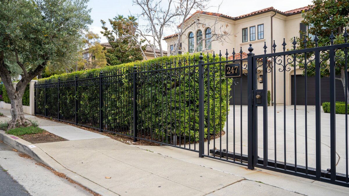Ornamental metal fence in front of a luxury home