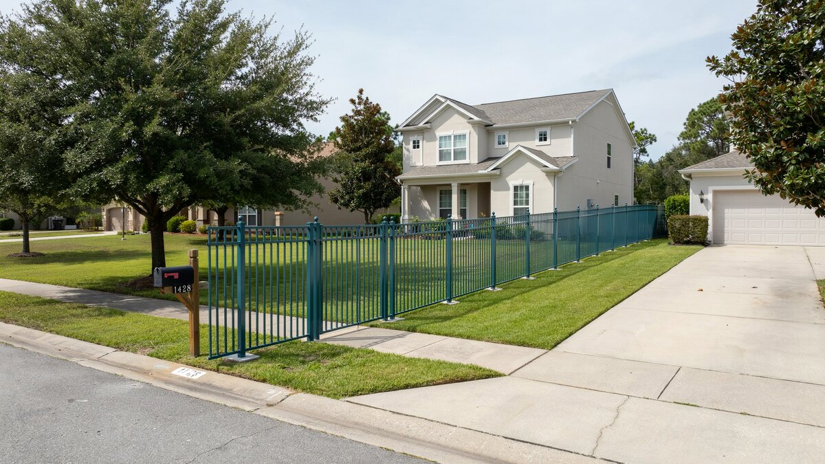 Green aluminum fence around a residential property