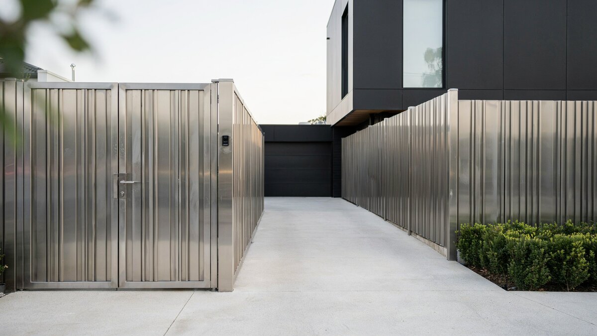 Brushed stainless steel gate and fence at a modern entrance