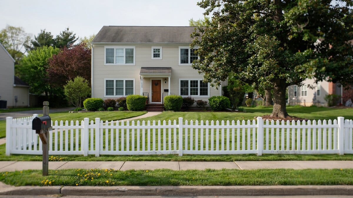 White plastic picket fence in a home's front yard