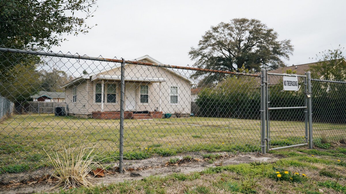Chain link fence surrounding a modest house yard