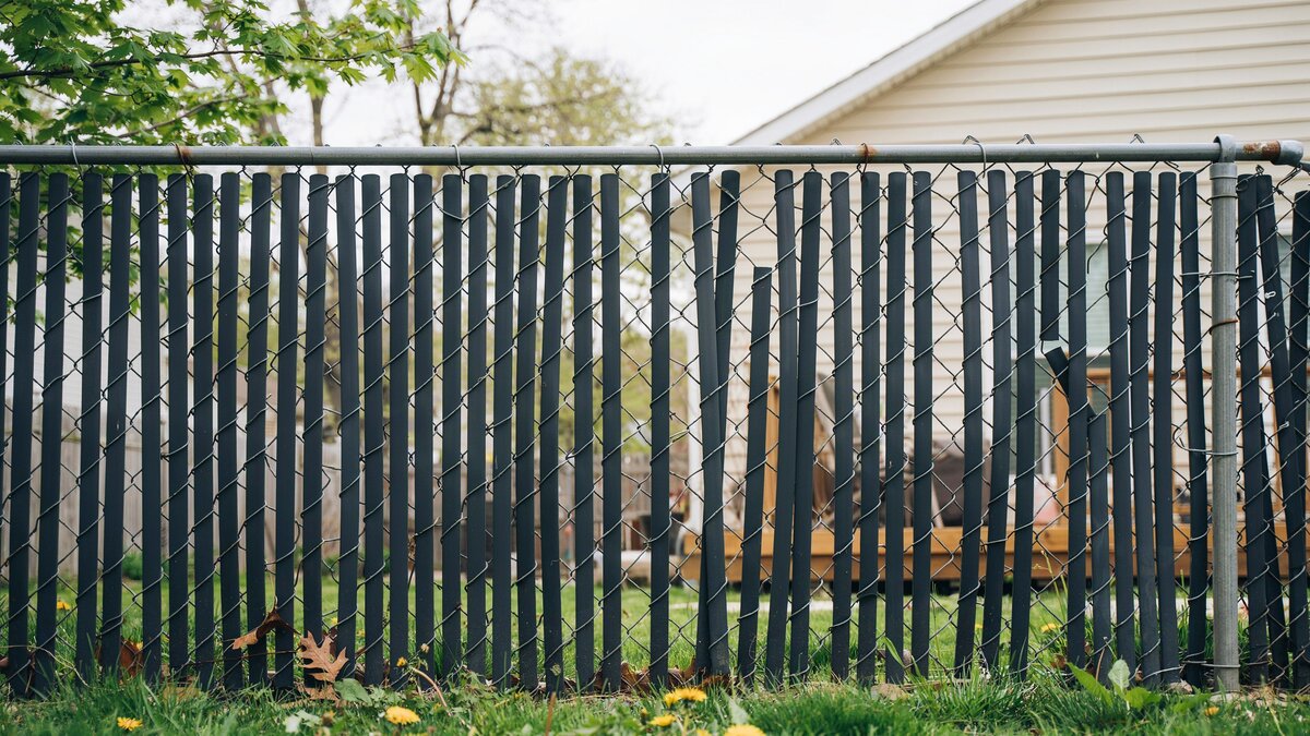 Chain link fence woven with vertical privacy slats