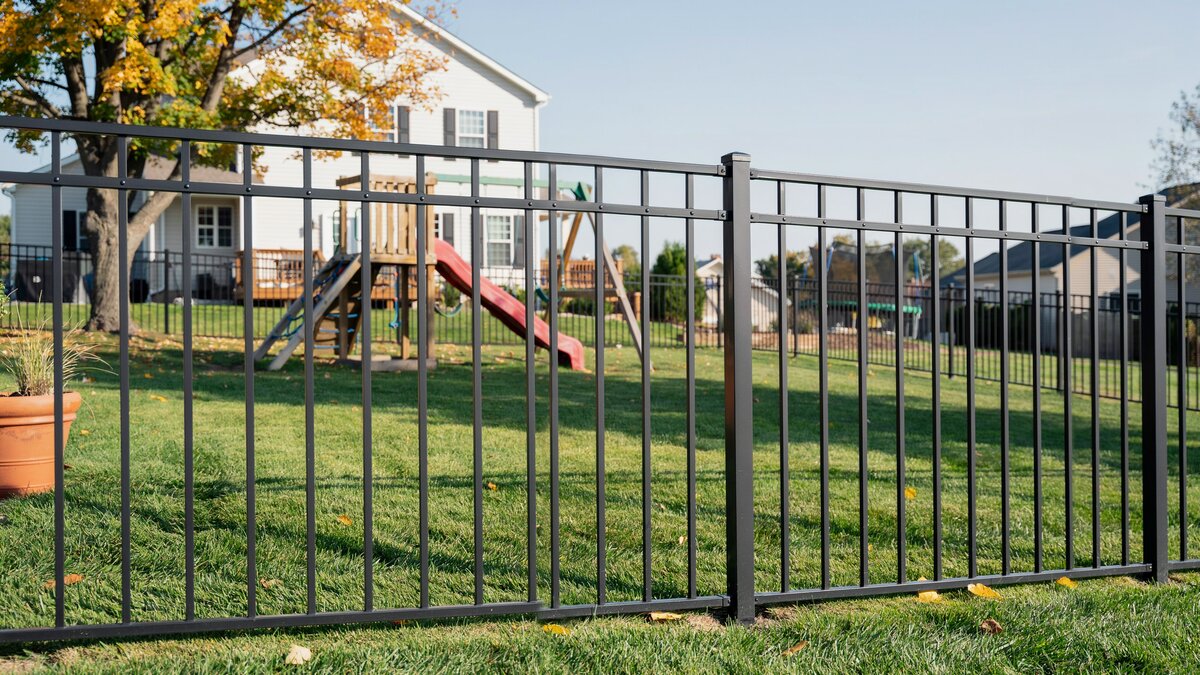 Modern metal safety fence around a backyard play area