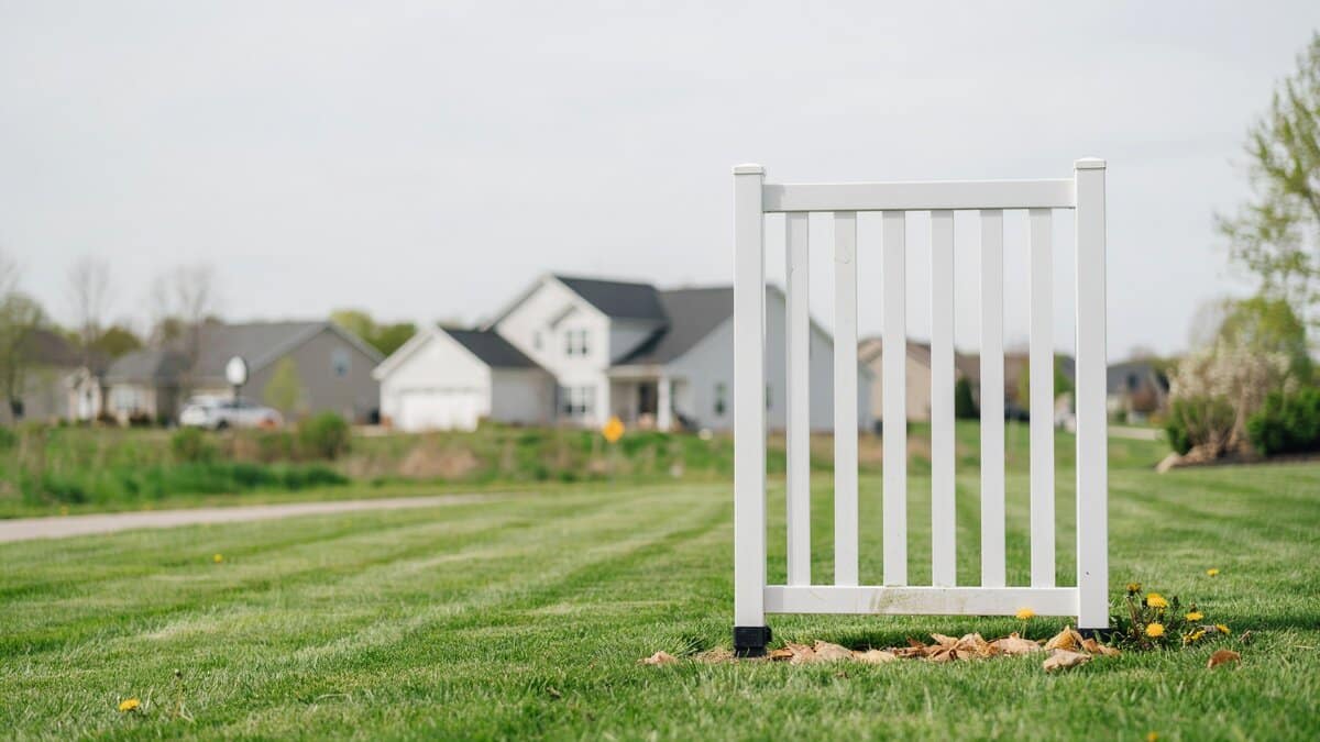 Small white vinyl temporary fence section on a lawn