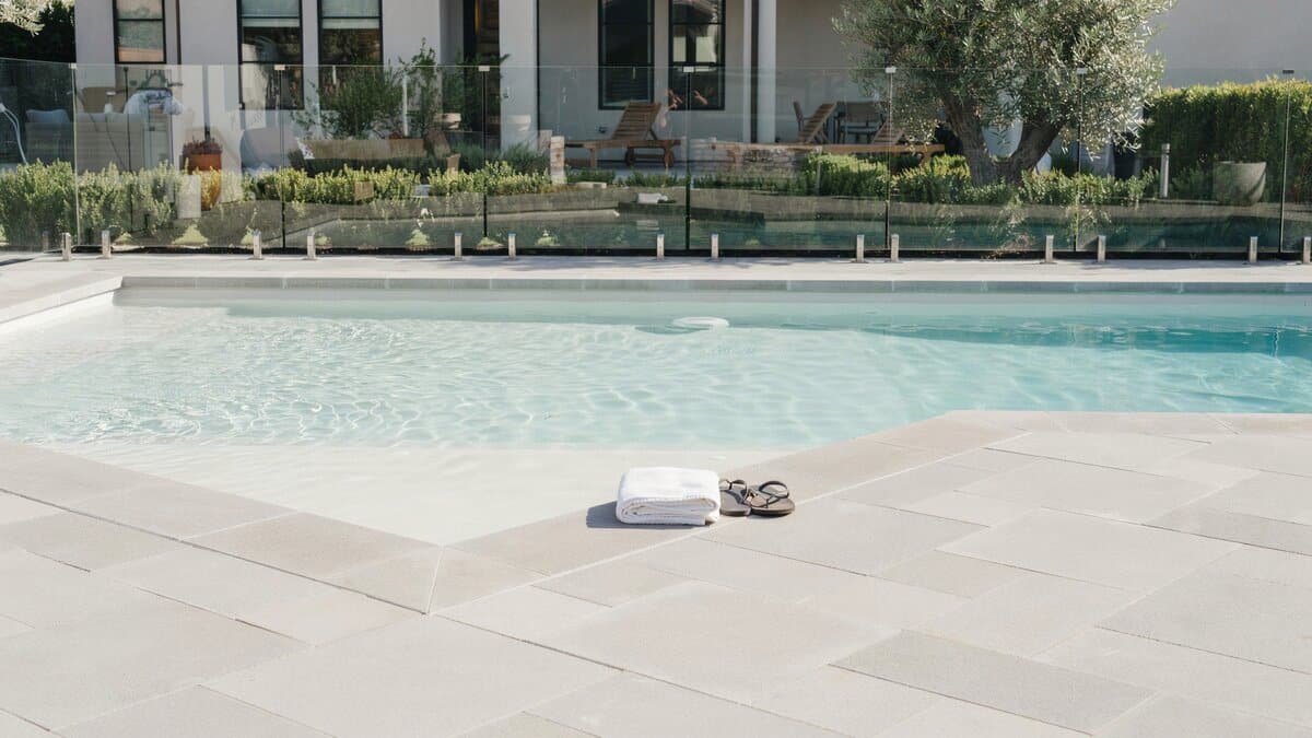 Frameless glass fence around a backyard swimming pool