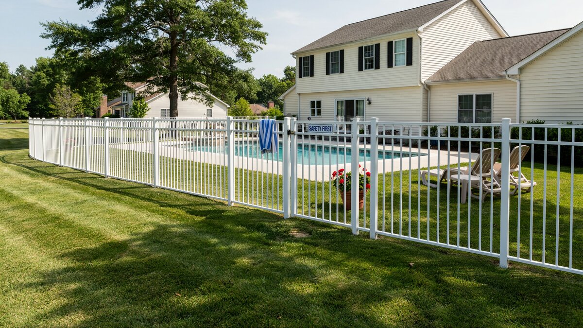 Backyard swimming pool enclosed by a safety fence