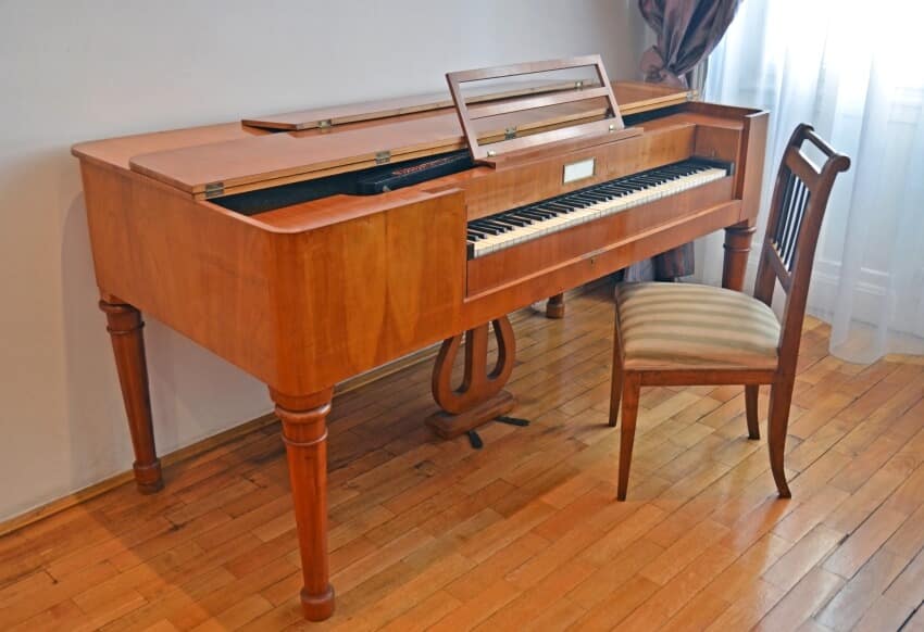 A spinet piano on panel floor